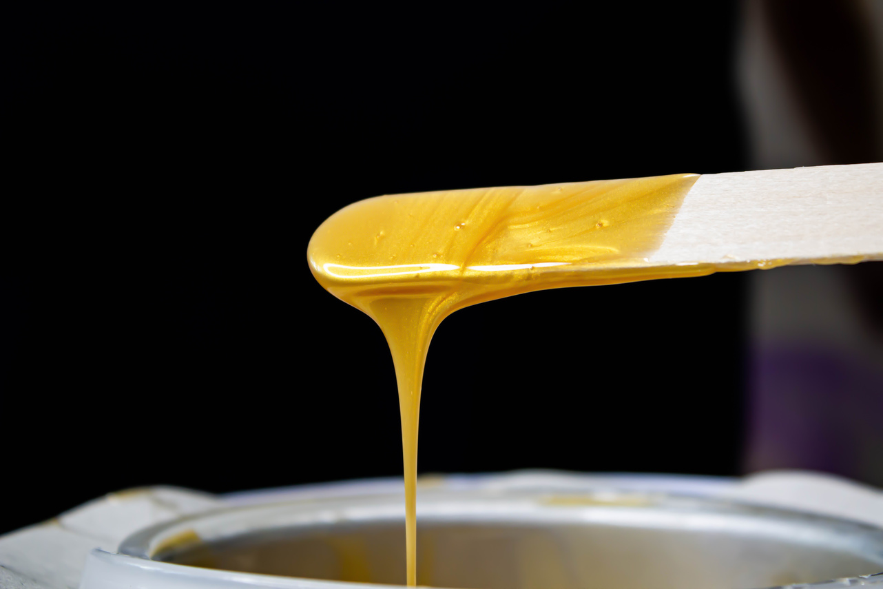 Melted depilatory wax. Sugaring wax. The girl removes her hair.